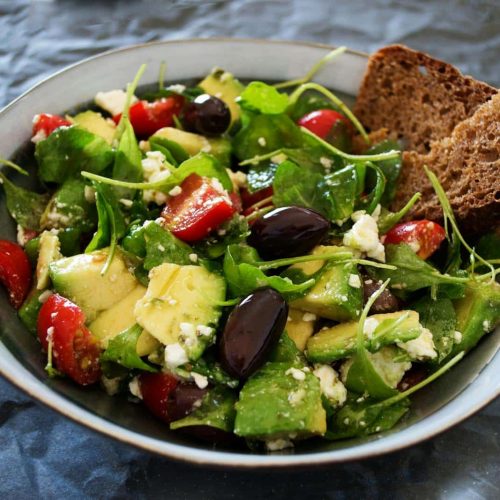 Delicious Greek salad featuring avocado, feta, and olives, ideal for a healthy meal.