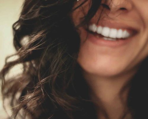 long black haired woman smiling close-up photography