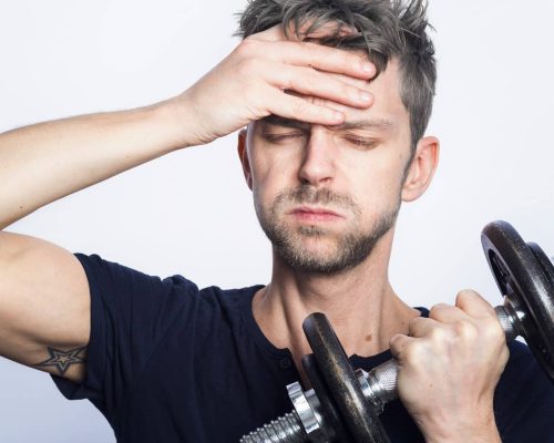 man in black crew neck t-shirt holding black dumbbell