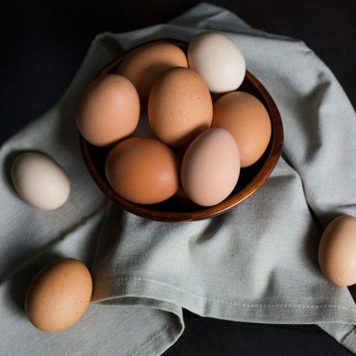 beige and white eggs on brown wooden bowl