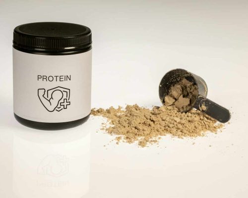 a jar of protein powder next to a scoop of protein powder
