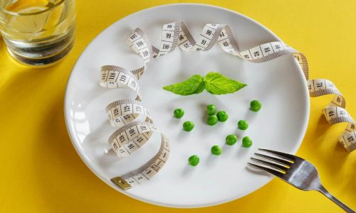 DASH Diet - A white plate topped with peas and measuring tape