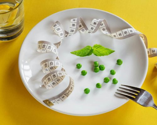 DASH Diet - A white plate topped with peas and measuring tape