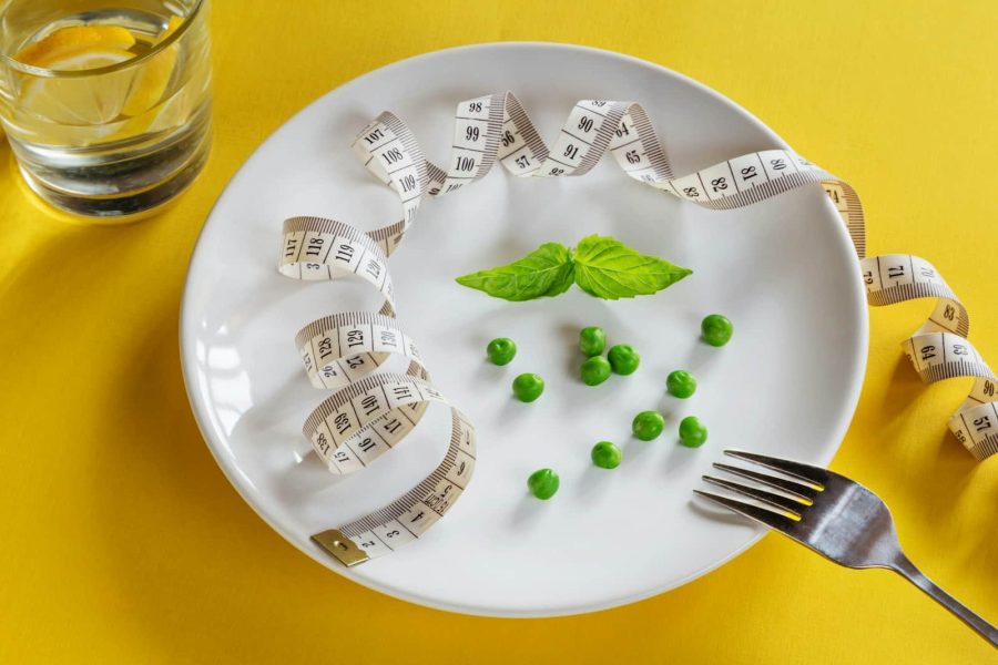 DASH Diet - A white plate topped with peas and measuring tape